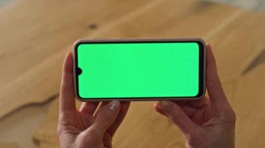 Ofisteki yeşil ekran telefon bayanının elleri kapalı. Kapalı alanda telefon şablonu izleyen isimsiz bir kadın. Bilinmeyen iş kadını e-posta okuyor yatay krom tuşlu akıllı telefondaki interneti arıyor