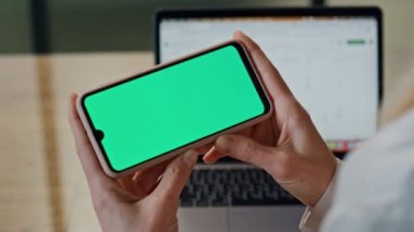 Direktör içeride yeşil ekran cep telefonunu yakından izliyor. İsimsiz iş kadını elinde yatay krom anahtar akıllı telefon tutuyor. İnternet üzerinden arama uygulaması kullanan kadın parmakları