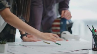 Mimarlık bürosuna el kol hareketi yapan yakın çekim yaratıcıları. Çeşitli meslektaşlar panoramik pencerelerde inşaat planını tartışıyor. Modern apartmanın baş tasarımcısıyla fikirleri paylaşan ilham verici bir kadın.