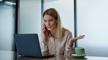 Heyecanlı bayanın ofis kapanışında yaptığı akıllı telefon araması. Duygusal iş kadını dizüstü bilgisayar ekranı görünümlü el hareketleriyle toplantı odasında. Mutlu yönetmen konuşuyor cep telefonu başarılarının tadını çıkar