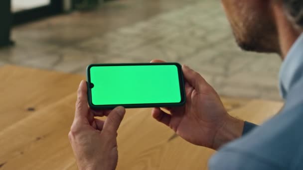 服装店的生意人在屋里看模拟电话 不知名的正式老板使用彩色屏幕智能手机 成年导演手牵着水平绿色显示屏手机上网 传播概念 — 图库视频影像