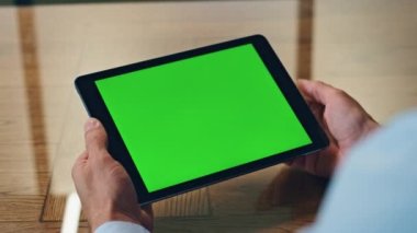 Adamın eli kapalı alanda yeşil tablet ekrana dokunuyor. Bilinmeyen işadamı, ofis odasında krom anahtar bilgisayar kullanarak sosyal medyayı kontrol ediyor. Tanımlanamayan yönetici internette gezinen bir model aygıt tutuyor 