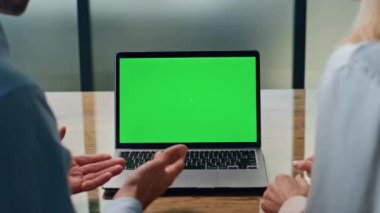 Girişimci çift iş yerinde laptopla görüntülü sohbet yapıyor. Bilinmeyen yönetici ekibi internet üzerinden iş arkadaşlarıyla konuşuyor. Yakın çekim. İş adamları kromakey aygıtı kullanarak stratejiyi açıklıyorlar 