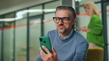 Portre başarılı adam içerideki telefonu arıyor. Lobi bölgesinde el kol hareketi yapan mutlu yönetmen. Pozitif yönetici ofisteki iş ortağıyla cep telefonu görüşmesi yapıyor.
