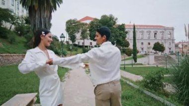 Bahçe yolunda koşan evli bir çift. Pozitif erkek kadın yaz doğasında el ele tutuşup eğleniyor. Heyecanlı, neşeli sevgili birlikte gülüyor, parktaki romantik buluşmanın keyfini çıkarıyor.