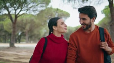 Mutlu mutlu çift sonbahar ormanında sakin bir yürüyüş yapar. Kapatın. Kaygısız yürüyüşçüler doğa parkında neşe içinde geziniyorlar. Aşık pozitif turistler hafta sonu seyahatlerinde sırt çantalarıyla dinleniyorlar.