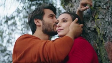 Yakışıklı bir adam ormanda dikilirken genç bir kadının yüzünü okşuyor. Sakallı çekici adam güzel kızı doğada öpüyor. Romantik hafta sonunun tadını çıkaran mutlu bir çift. Tarih kavramı.