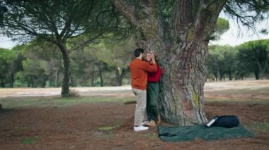 Sevgi dolu bir çift, doğada romantik bir hafta sonunun tadını çıkarır. Genç mutlu turistler güzel bir parkta geniş bir ağacın yanında dikiliyorlar. Sevimli iki insan, sonbahar ormanlarında birlikte vakit geçirir..