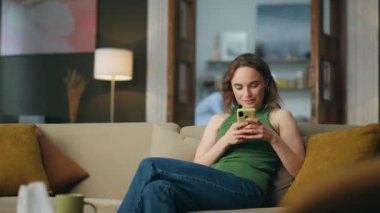 Rahatlamış iş kadını evde akıllı telefon mesajları atıyor. Yerel atmosferde cep telefonunu daktilo eden serbest çalışan bir kadın. Kanepe başında e-posta okuyan bir kadın. Cep telefonu ekranına bakan kız 
