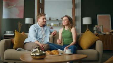 Sevgi dolu bir çift evdeki kanepede dinleniyor. Erkekle konuşan gülümseyen kadın. Mutlu koca dinleyen eş sabah atmosferinin tadını çıkarıyor. Romantik eşler hoş vakit geçiriyorlar. Neşeli aile kavramı 