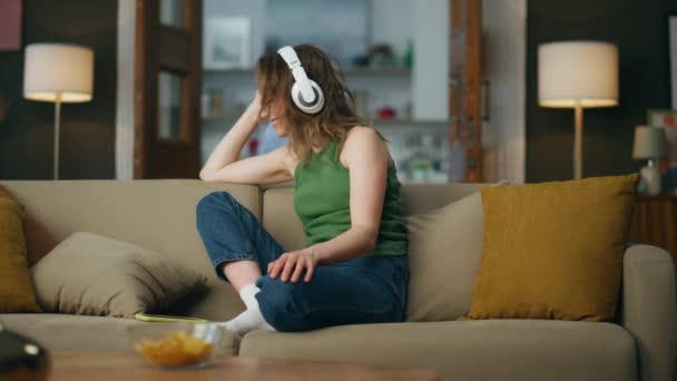 Çeride Müzik Dinleyen Kulaklıklı Kadın Kanepede Gülümsüyor Mutlu Kadın Evde — Stok video