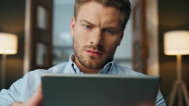 Odaklanmış adam bilgisayardan uzaklaşır. Ciddi bir iş adamı, oturma odasının iç kısımlarında dijital cihaz kullanarak projeyi inceliyor. Akşam dairesindeki oturma koltuğunu yakınlaştıran adamla ilgili. 