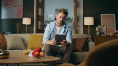 Düşünceli adam tablet masasını eve koyuyor. Düşünen adam çözümü tek başına düşünüyor. Aklı karışmış serbest çalışan akşam oturma odasında koltukta oturuyor gibi görünüyor. Halk yaşam tarzı konsepti