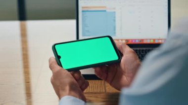 Patron parmakları ofiste cep telefonunu yakın çekimde tutuyor. İsimsiz lider yeşil ekran şablon cihazını izliyor. Bilinmeyen CEO görünümlü kroma anahtar telefon masada dinleniyor. Finansal analist gazete okuyor. 