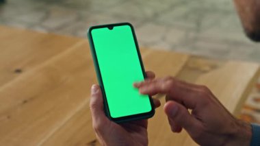 Dolaba yakın çekimde kullanıcı kromakey akıllı telefonu. İş adamı ofisinde şablon cihazını tutuyor. Tanımlanamayan işadamı sıcak iş yerinde yeşil ekran cep telefonu ağı kullanıyor.