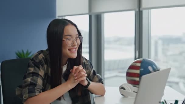 笑いの女性は コンピュータのフラットクローズアップでビデオ通話を話す 正の女の子は ラップトップの仮想チームの建物のオフィスに座って話す オンライン会議でプレゼンテーションを提供する陽気な開発者 — ストック動画