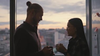 Konuşan insanların siluetleri akşam ofislerinde dinleniyor. İş arkadaşları panoramik pencere odasında cappuccino içiyor. İşten sonra iletişim kuran bilinmeyen gençler. Aşk çifti flört ediyor.