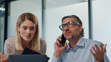 Heyecanlı ofis çalışanları kapalı mekanda eğleniyorlar. Gülümseyen kadın meslektaşlar başarılı bir proje kazanıyor. Mutlu iki iş ortağı işten memnun kalmış. Kurumsal başarıyı kutluyorlar. 