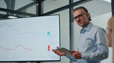 Karizmatik iş adamı ofis içinde televizyon ekranını gösteriyor. Gülen akıl hocası konferans odasında yatırımcı grubuna başarılı bir şekilde yeni ticari ürün sunuyor. Sunum konsepti toplanıyor