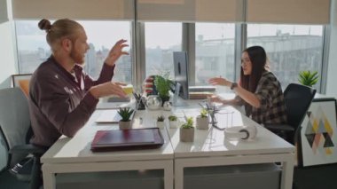 Küçük bir çalışma odasında beyin fırtınası yapan oyuncu meslektaşlar. Mutlu iş arkadaşları sunumu tartışıyor. Kadın ve erkeğin birlikte çalışması. Serbest çalışanlar keyifli konuşuyorlar. Ortaklık kavramı