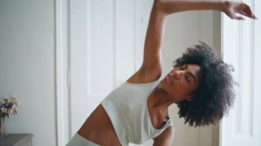 Yogacı kız yamaçları kapatıyor. Atletik kadın evde Asana 'yı oynuyor. Sportif bayan sabah apartmanında uzun kenar açılı poz veriyor. Afrika kökenli Amerikalı spor eğitmeni içeride vücut esnetiyor 