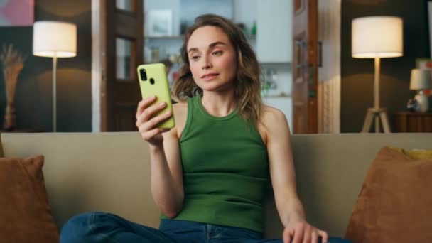 Menina Videocalling Telefone Sofá Interior Closeup Menina Sorrindo Gesticulando Mão — Vídeo de Stock