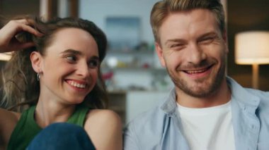 Pov gülümseyen aşıklar hafta sonu evde gülüyorlar. Duygusal mutlu çift akşamları birlikte oturup komedi filmi izliyorlar. Kaygısız, heyecanlı çift oturma odasının iç tarafındaki komik şovu izliyor.