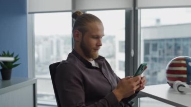 Düşünen adam hipster odasında cep telefonunu kontrol ediyor. Sakin, genç görünümlü pencereler şehir manzaralı dairede akıllı telefon tutuyor. Ciddi bir yönetici modern ofiste tek başına bir mesaj yaratıyor.