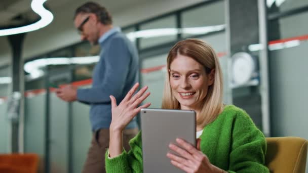 快乐的员工视频聊天平板电脑在工作场所的特写 快乐的女商人在办公室的视频网上聊天 微笑的女导演举手表决垫电脑会议 — 图库视频影像