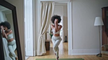 Yoga mankeni evde zum yapıyor. Afrikalı kadın evde vücut germe hareketleri yapıyor. Tek bacaklı bir bayan sabah dairesinde poz veriyor. Farkındalık yaşam tarzı dengesi