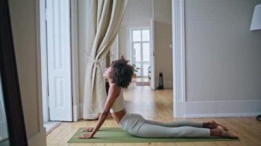 Güçlü kadın kobra pozu evde pratik yapıyor. Afrikalı formda bir kız sabahları yoga eğitimi veriyor. Atletik sporcu kadın özel halı döşemesinde egzersiz yapıyor. Sağlık ve zindelik kavramı 
