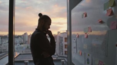 Sunset View Hall 'da beyaz tahta üzerinde kafa yoran bir adam silueti. Karanlık ofiste düşünen kimliği belirsiz bir müteahhit. İsimsiz girişimci, büyük pencerelerin iş yerinde geç saatlere kadar çözüm bulmaya çalışıyor