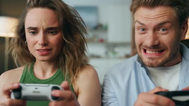 竞争的一对拿着游戏垫在家里的肖像 感情上的女朋友男朋友在一起玩网络游戏视频很开心 神经质的女人失去了兴奋的男人赢家感到快乐 — 图库视频影像
