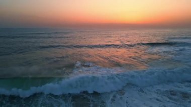 Köpüklü dalgalar sahil manzarasını bozuyor. Şafak vakti ufuk çizgisi. Volkanik dağ yavaş çekim üzerine çarpan dramatik fırtınalı deniz. Vahşi su sabah tehlikeli kayalara çarpıyor. Doğa uzaklaşıyor.