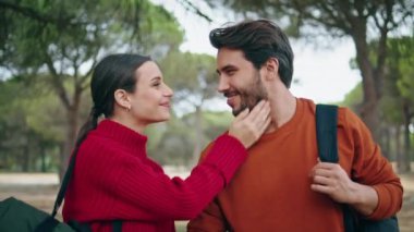 Aşık mutlu turistler güzel sonbahar ormanlarında yürürken öpüşüyorlar. Kaygısız genç çift, şefkatli bir şekilde gezintiye çıkmanın tadını çıkarıyor. Romantik çift hafta sonunu doğa parkında geçiriyor..