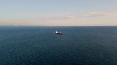 Mavna taşıyıcı okyanus yüzeyi drone görüntüsü. Panoramik büyük kargo gemisi açık hava gününde derin sularda süzülüyor. Yalnız konteynır tankeri deniz lagününden geçiyor. Deniz taşımacılığı lojistik kavramı