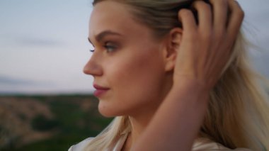 Gün batımında gülümseyen kadın yakın plan. Deniz fenerinin arka plan portresinde kameraya bakan rüya kadın. Yaz tepesinde akşam ışığında poz veren kadın model. Genç kız rahatlatıcı manzara ortamı