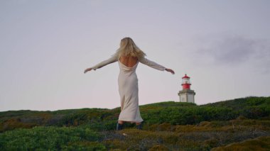 Şehvetli kadın döner kule manzarası. Tasasız kız yaz tatilinde eğleniyor. Güzel bir bayan model tepe poz veriyor. Elbiseli bayan deniz feneri tatili. Uyum kavramı