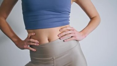 Beyaz Duvar 'da kadın figürlü antrenman vücudu. Spor salonunda el ele tutuşup egzersiz yapan isimsiz atletik kız. Evde tanınmayan bir sabah sporu. Spor rutin konsepti