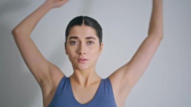 Spor yapan kadın evde elini uzatıyor. Yakından. Ateşli esmer kadın ısınıyor ve içeride çalışmaya hazırlanıyor. Açık iç dairede spor giyinen kız egzersizi yapıyor. Sağlık ve refah kavramı 