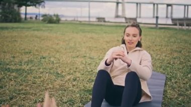 Açık havada motivasyonlu bayan spor eğitimi. Alkışlayan sporcu kız arkadaşlarıyla çiftler halinde çalışmaktan zevk alıyor. Karın kası egzersizi yapan iki kadın. Sağlıklı yaşam tarzı ve ilişki kavramı