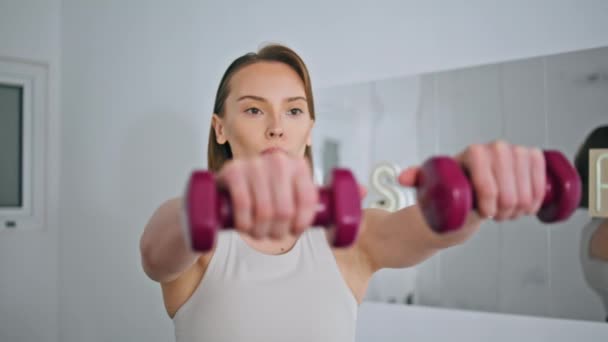 重点是女子体重训练室内特写 认真的运动教练单独进行武器训练以增强肌肉 早操俱乐部使用哑铃提高核心稳定性 — 图库视频影像