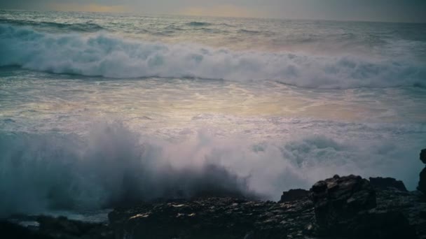 海岸線の石を壊す泡の波が閉じます スローモーションで爆発を作る岩を打つ強力な海の圧延海岸 美しい泡の海のスプラッシュ野生の海岸 風光明媚な海辺の概念を旅行 — ストック動画