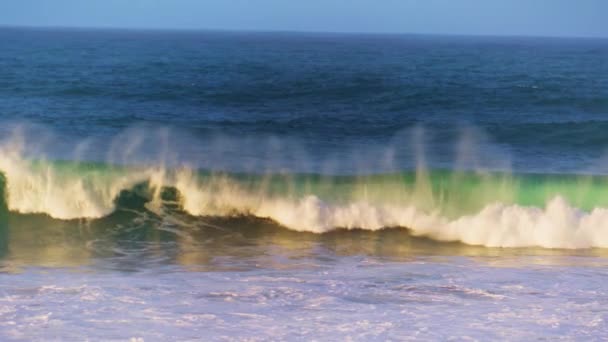 超遅い動きで浅い方へと回転する朝の海の波 晴れた日には白い海泡が水面を吹き飛ばしています 海辺で強力な水がクラッシュします 夏の冒険嵐の熱帯海岸 — ストック動画
