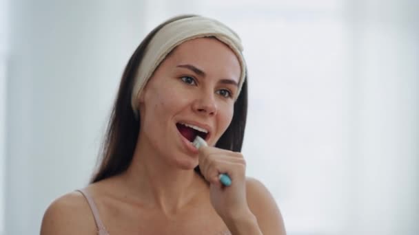 微笑的女士在浴室做牙齿卫生关闭 布鲁内特阳性女人在镜子前刷牙 可爱的女孩用牙膏去除牙菌斑来清洁嘴 日常概念 — 图库视频影像
