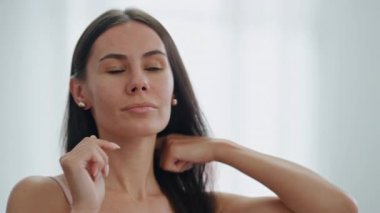 Banyoda takı takan neşeli bir manken. Memnuniyet duyan bir kadın evde aynaya küpe takıyor. Gülümseyen kız saçlarına dokunup yeni aksesuarlarla poz veriyor. Özsaygı kavramı 