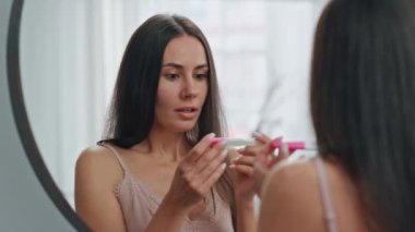 Heyecanlı bayan gebelik testi yakın çekim evinde yapılıyor. Aynaya bakan mutlu kadın tuvalette olumlu sonuç veriyor. Gülen kız, çocuğun duygusal tepki vermesini bekliyor. Gelecekteki annelik kavramı