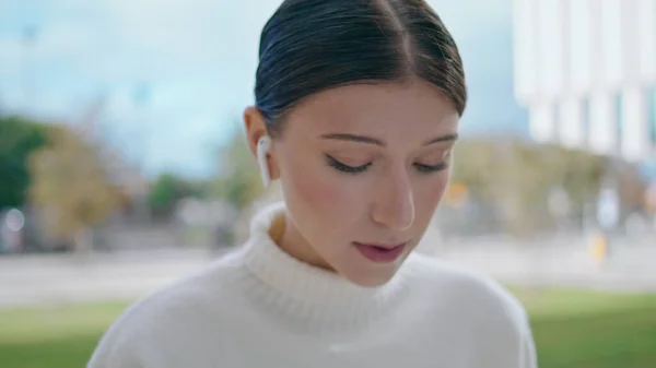 Portrait Attractive Woman Talking Outdoors Using Modern Wireless White Earbuds — kuvapankkivalokuva