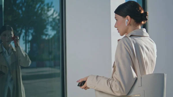 Young Business Woman Taking Wireless Earbuds Watching Window Reflection Outdoors — Stock fotografie