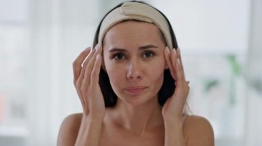 Endişeli bayan banyo odasındaki kırışıklıkları kontrol ediyor. Yakın plan stresli kadın kötü cilt hastalığına üzülüyor. Sinirli model mimik kasları inceliyor. Ev portresindeki estetik estetik ameliyatları düşünüyor.